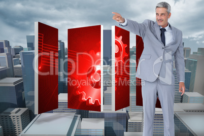 Composite image of handsome businessman pointing away