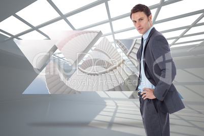 Composite image of serious businessman with hands on hips