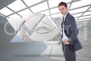 Composite image of serious businessman with hands on hips