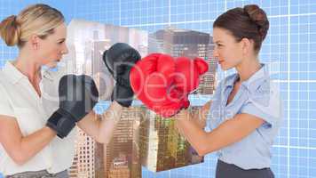 Composite image of businesswomen with boxing gloves fighting