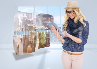 Composite image of smiling trendy blonde using tablet computer