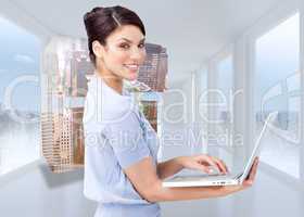 Composite image of cheerful businesswoman using a laptop