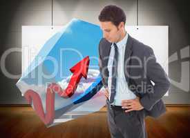 Composite image of serious businessman standing with hands on hi