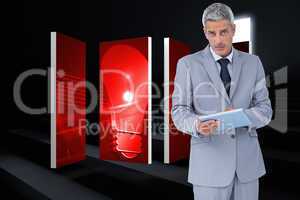 Composite image of serious businessman using tablet pc looking a