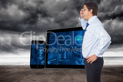 Composite image of thinking businessman tilting glasses