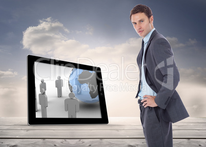 Composite image of serious businessman with hands on hips