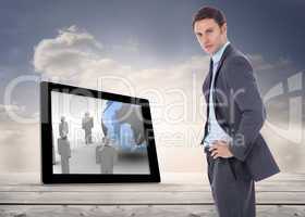 Composite image of serious businessman with hands on hips