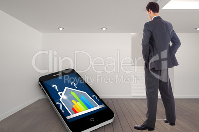 Composite image of businessman standing with hands on hips