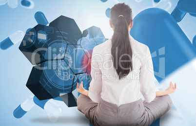 Composite image of businesswoman sitting in lotus pose