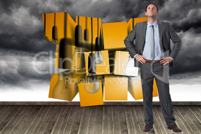 Composite image of serious businessman with hands on hips