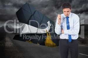 Composite image of thinking businessman holding pen