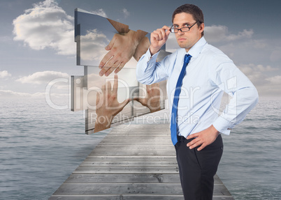 Composite image of thinking businessman tilting glasses