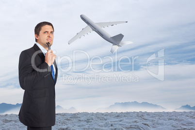 Composite image of thinking businessman holding glasses