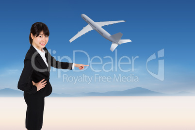 Composite image of smiling businesswoman pointing