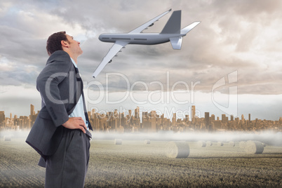 Composite image of cheerful businessman standing with hands on h