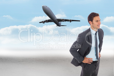 Composite image of cheerful businessman standing with hand on hi