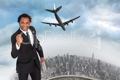 Composite image of happy businessman with fist