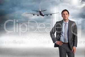 Composite image of serious businessman with hand on hip