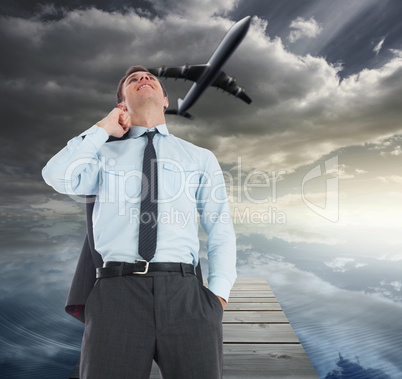 Composite image of smiling businessman holding his jacket