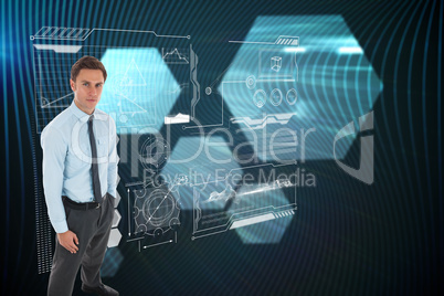 Composite image of serious businessman standing with hands in po