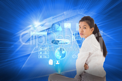 Composite image of businesswoman sitting cross legged frowning