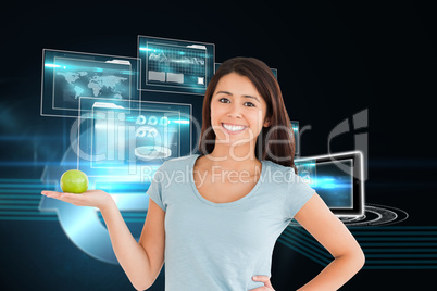 Composite image of good looking woman holding a green apple