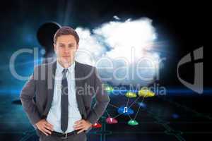 Composite image of serious businessman standing with hands on hi