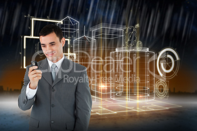 Composite image of smiling businessman looking at his cellphone