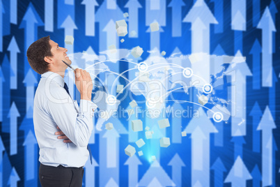 Composite image of thinking businessman holding pen