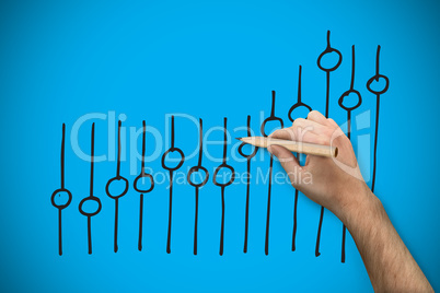 Composite image of hand holding a pencil