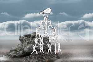 Composite image of team holding up light bulb