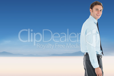 Composite image of happy businessman standing with hand in pocke