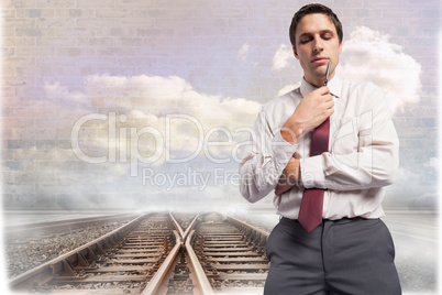 Composite image of thoughtful businessman holding pen to chin