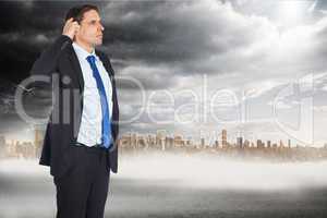 Composite image of thinking businessman scratching head