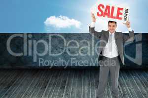 Composite image of businessman with sign above his head