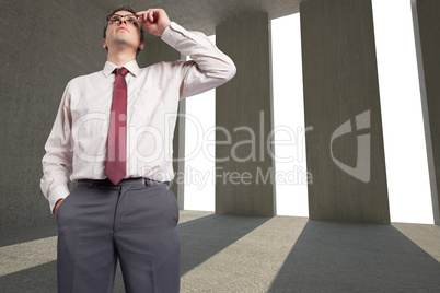 Composite image of thinking businessman touching his glasses