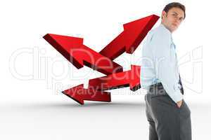 Composite image of serious businessman standing with hands in po