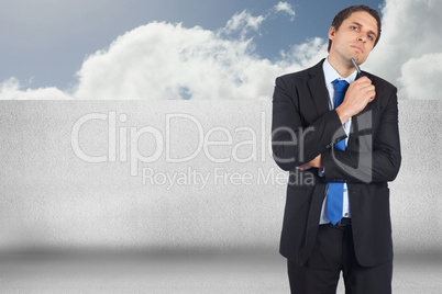 Composite image of thinking businessman holding pen