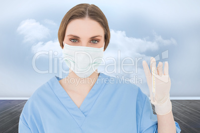 Composite image of young female doctor holding a thermometer