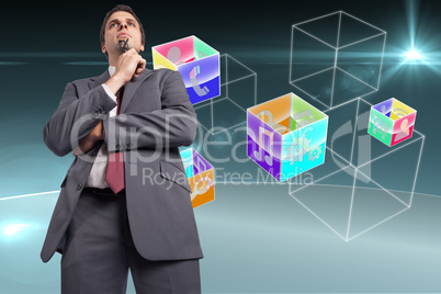 Composite image of thinking businessman holding his glasses