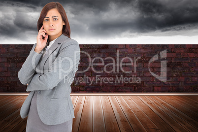 Composite image of worried businesswoman