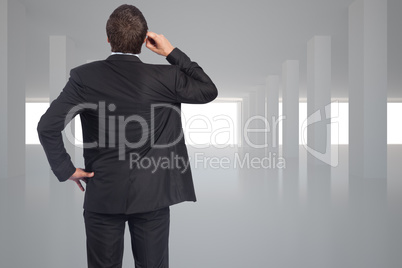 Composite image of thinking businessman scratching head