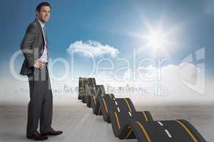 Composite image of smiling businessman with hands on hips