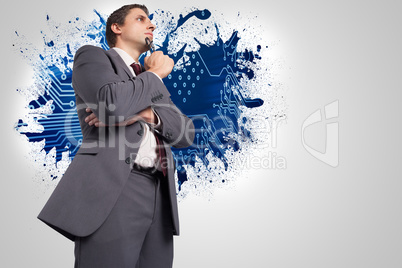 Composite image of thinking businessman holding his glasses