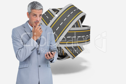 Composite image of worried businessman holding his cellphone
