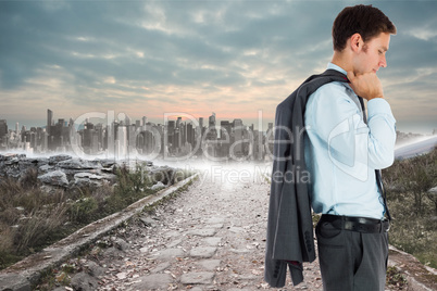 Composite image of serious businessman holding his jacket