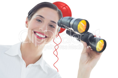 Composite image of smiling business woman with binoculars