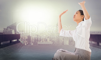 Composite image of businesswoman sitting cross legged pushing up