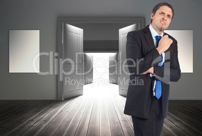 Composite image of thinking businessman holding pen