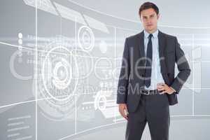 Composite image of serious businessman with hand on hip